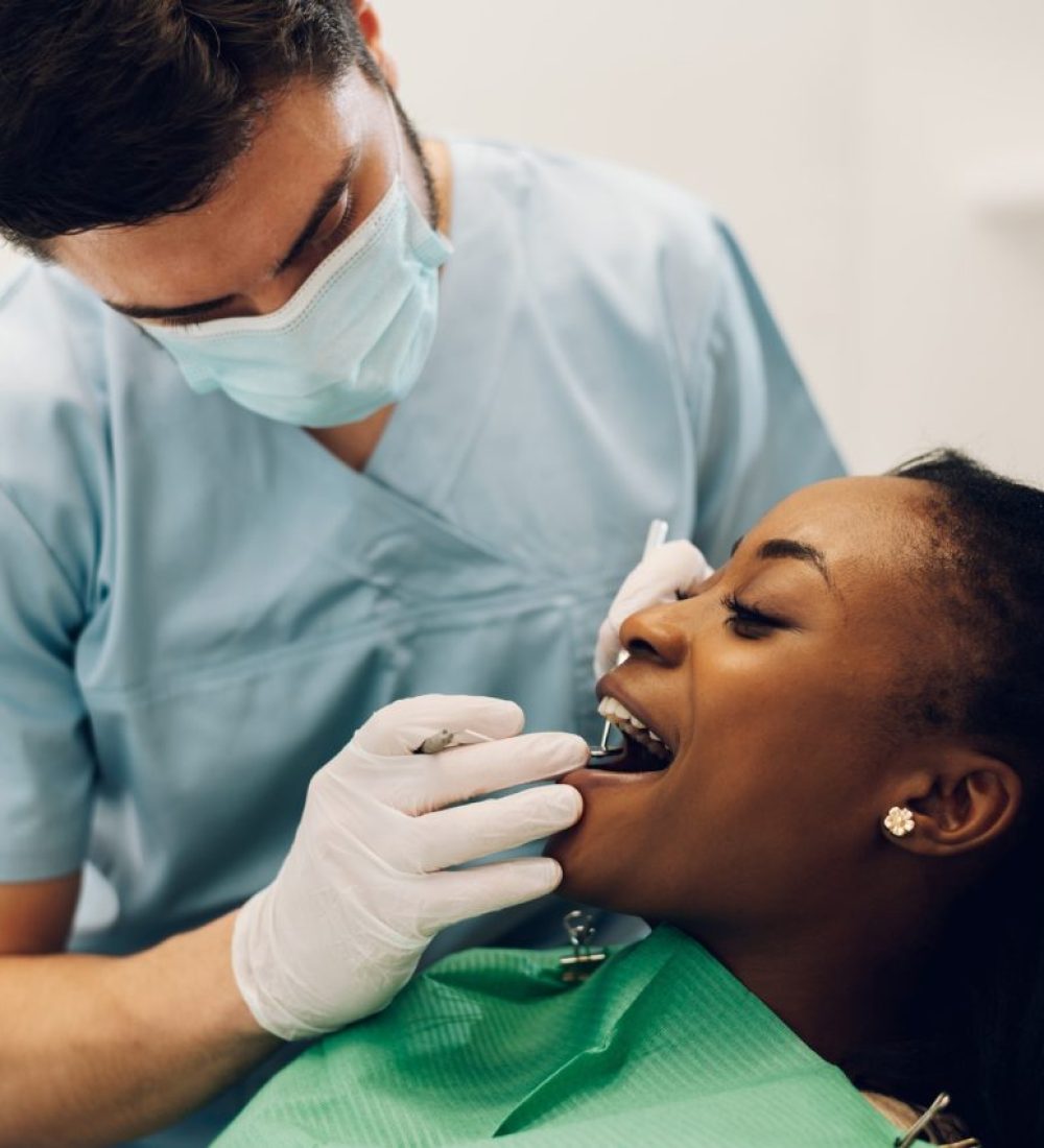 dentist-providing-dental-care-treatment-to-a-african-american-female-patient.jpg